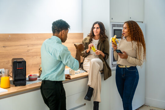 Diverse colleagues taking a break discussing lifestyle in office kitchen