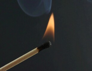 A lone match flame against a dark background glow