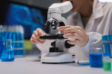 Research scientist placing sample on microscope stage