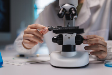 Scientist adjusting microscope for scientific research and analysis