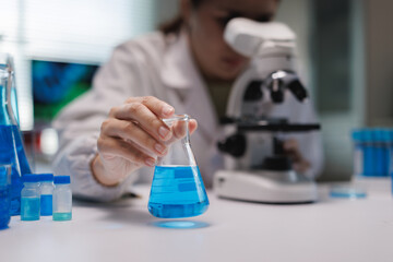 Scientist holding chemical flask for scientific experiment in lab