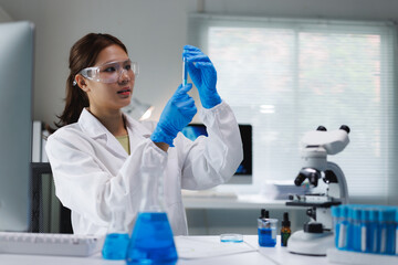 Female scientist examining liquid in laboratory test tube