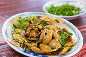 Taiwanese restaurant cooking stir fry clams on stove