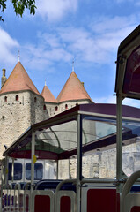 Carcassonne Cité, France, entrance, little tourist train and Dame Carcas statue in the background 