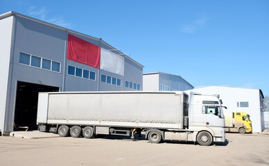 A large truck is unloading at a warehouse	