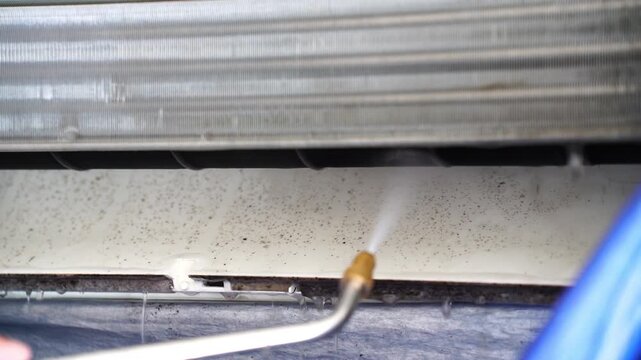 Cleaning mold inside a split air conditioner unit using high-pressure water spray to remove dirt and bacteria, ensuring better air quality and energy efficiency for home and office environments.
