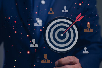 Businessman with a magnifier on a target bullseye. A concept for achieving business goals, successful marketing strategy, customer acquisition, and focusing on the correct audience.