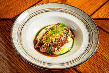 Tender beef rests on a bed of creamy mashed potatoes, enhanced by herbs and sauces