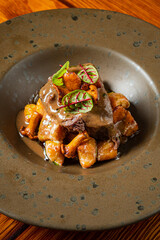 A chef-prepared plate features tender beef, rich sauce, and crispy golden gnocchi