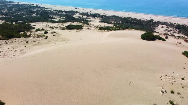 aerial perspective showcasing the vast Patara Sand Dunes meeting the pristine Patara Beach along the Mediterranean coastline in Antalya Province, Turkey. This footage captures the serene beauty of the