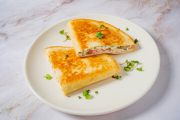 Delicious stuffed flatbread, golden and crispy, garnished with fresh greens, perfect for a snack