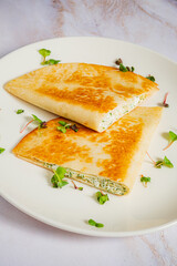 Savory pancakes are beautifully plated, featuring vibrant green fillings and crispy edges