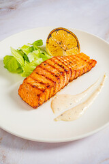Delicious grilled salmon accompanied by lemon and crisp salad garnishes, perfect for a healthy meal