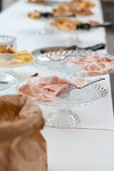 Elegant Buffet Display Featuring Sliced Cured Meats And Cheeses Arranged On Ornate Crystal Serving Platters