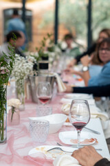 A Romantic Outdoor Wedding Reception Setting with People Celebrating Around a Table Filled with Flowers Food and Wine During the Daytime