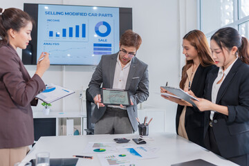 Asian businessman standing and presenting her work on a laptop

