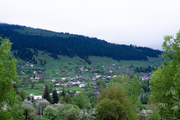 Carpathian Mountains. Clouds low above the mountains covered with spruce forests. City in the Carpathian Mountains.