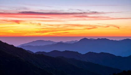 Vibrant Sunset Over Layered Blue Mountain Ridges