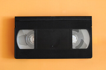 Obraz premium Black vhs video cassette tape on orange background