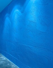 Arched lighting on a textured bright blue wall