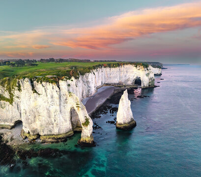 Aerial view of alabaster cliffs meet the turquoise sea, arches and stacks standing proud against the pastel sky, a timeless coastal drama unfolds, &Atilde;&permil;tretat, Normandy, France.