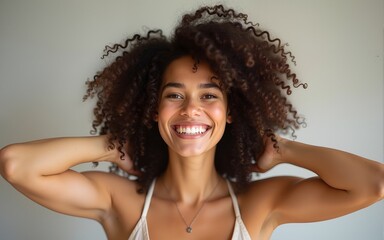 Radiant young woman with stunning curls makes scale with arms, feels happy and confident. High quality