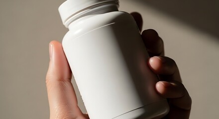 Hand holding a white pill bottle with a blank label