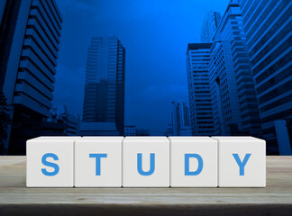 Study letter on white block cubes on wooden table over modern office city tower and skyscraper, Business, education and learning concept
