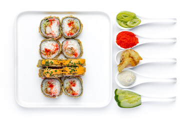 Sushi roll on a white plate on a perfectly white background with ingredients for it in white spoons isolated
