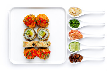 Sushi roll on a white plate on a perfectly white background with ingredients for it in white spoons isolated