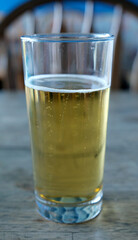 Glass of beer on a wooden table in a restaurant, close up, natural light