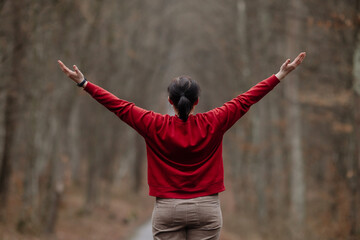 Young woman in red enjoying fresh air outdoors.