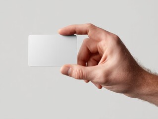 Obraz premium Male hand holding blank business card isolated on gray background