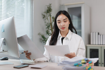Young woman organizing documents at office desk