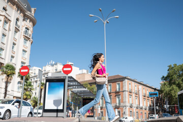Young woman walking city street enjoying carefree lifestyle
