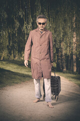 Senior citizen spending time alone in spring park with cart