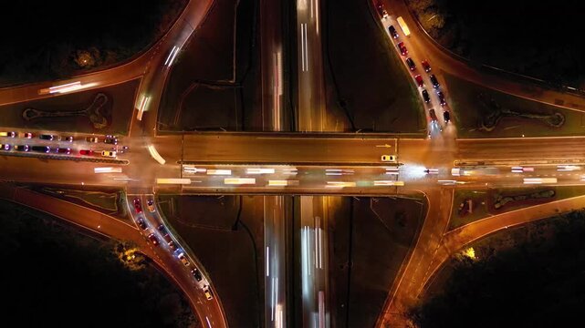 A highway with a lot of traffic. The bridge is lit up at night. Aerial view Larkin night traffic