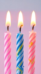 Three birthday candles with flames