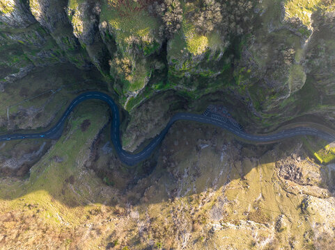 Aerial view of the winding road snaking through the dramatic cliffs, a ribbon of asphalt cutting through the rugged landscape, Cheddar Gorge, Cheddar, England, United Kingdom.