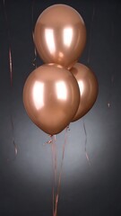 Three rose gold balloons against dark backdrop