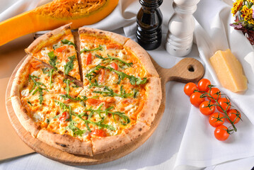 Pizza with pumpkin, cherry tomatoes and arugula