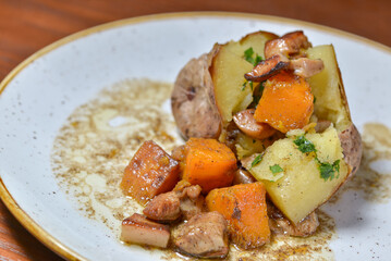 baked potatoes with meat and pumpkin on a plate macro photo