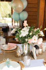 Elegant table setting with flowers and baby shower balloons
