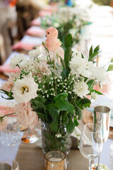 Baby shower table with floral centerpiece and teddy bear decoration
