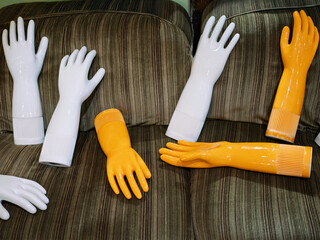Collection of Ceramic Glove-Like Art Pieces in White and Orange Tones Laying on Sofa