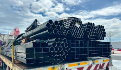 Construction products on transport vehicles Group of steel pipes for industrial materials Construction engineering products  equipment, steel pipes, metal warehouse industry, delivery to customers