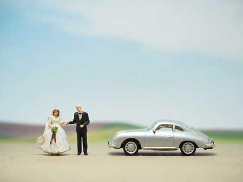 Mini toy of car and people with blurred background. Wedding photoshoot concept design.