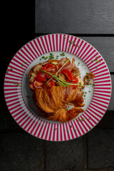Croissant with filling on a beautiful plate isolated