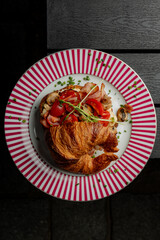 Croissant with filling on a beautiful plate isolated