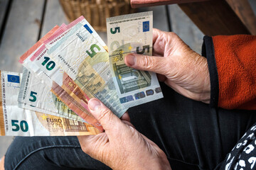 Euro, money in the hand of an elderly woman, pension.
